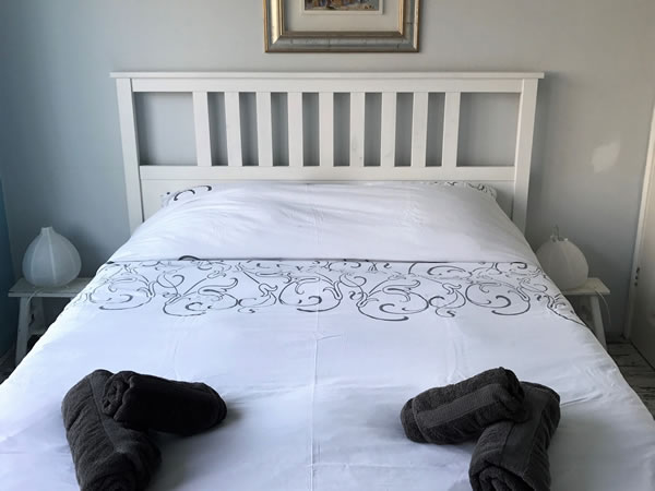Slaapkamer met tweepersoonsbed en handdoeken