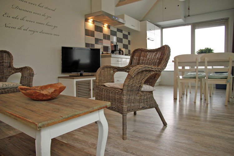 Woonkamer van Helmgras met rieten stoelen, televisie en eethoek